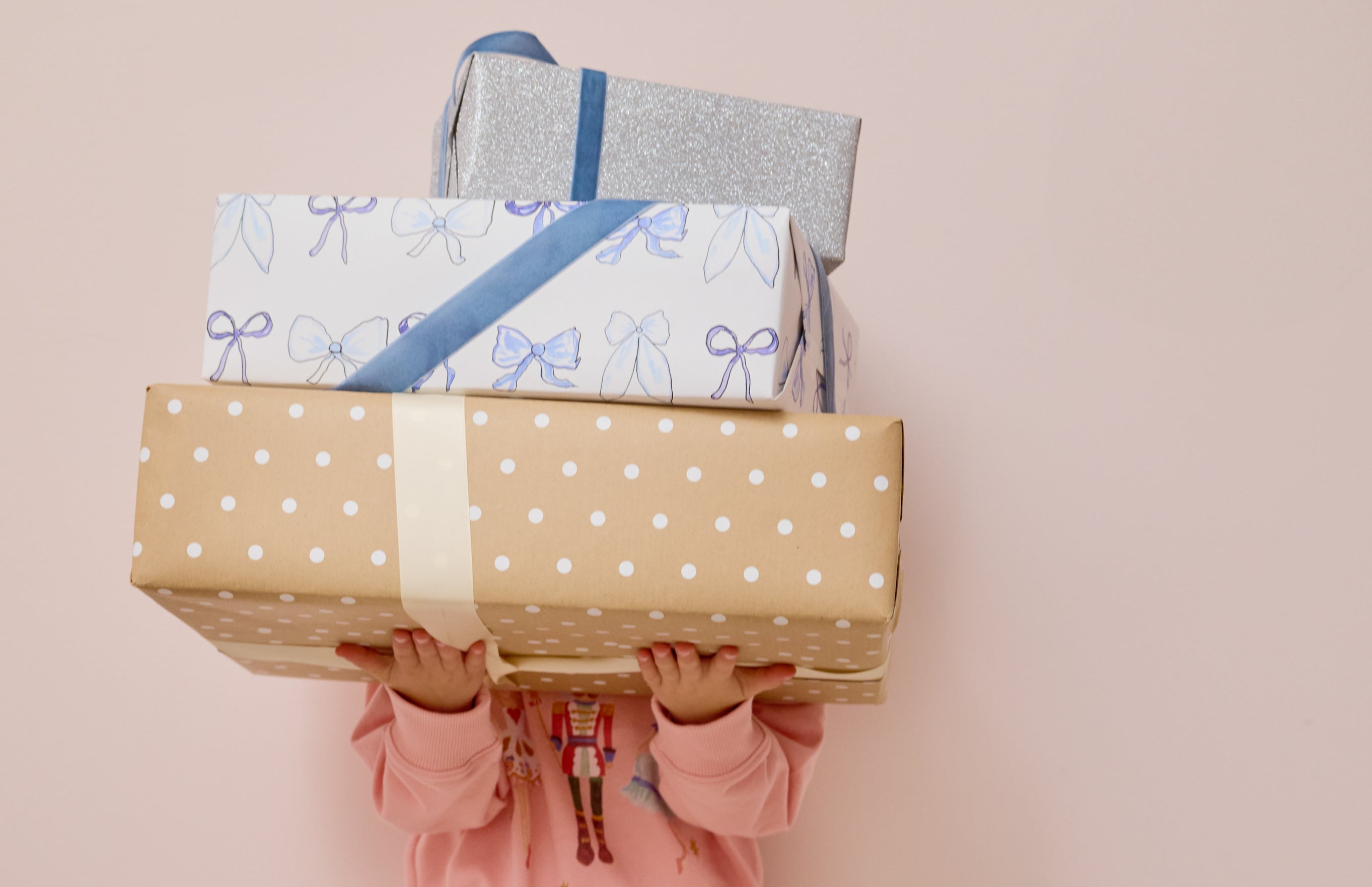 girl holding stack of 3 presents