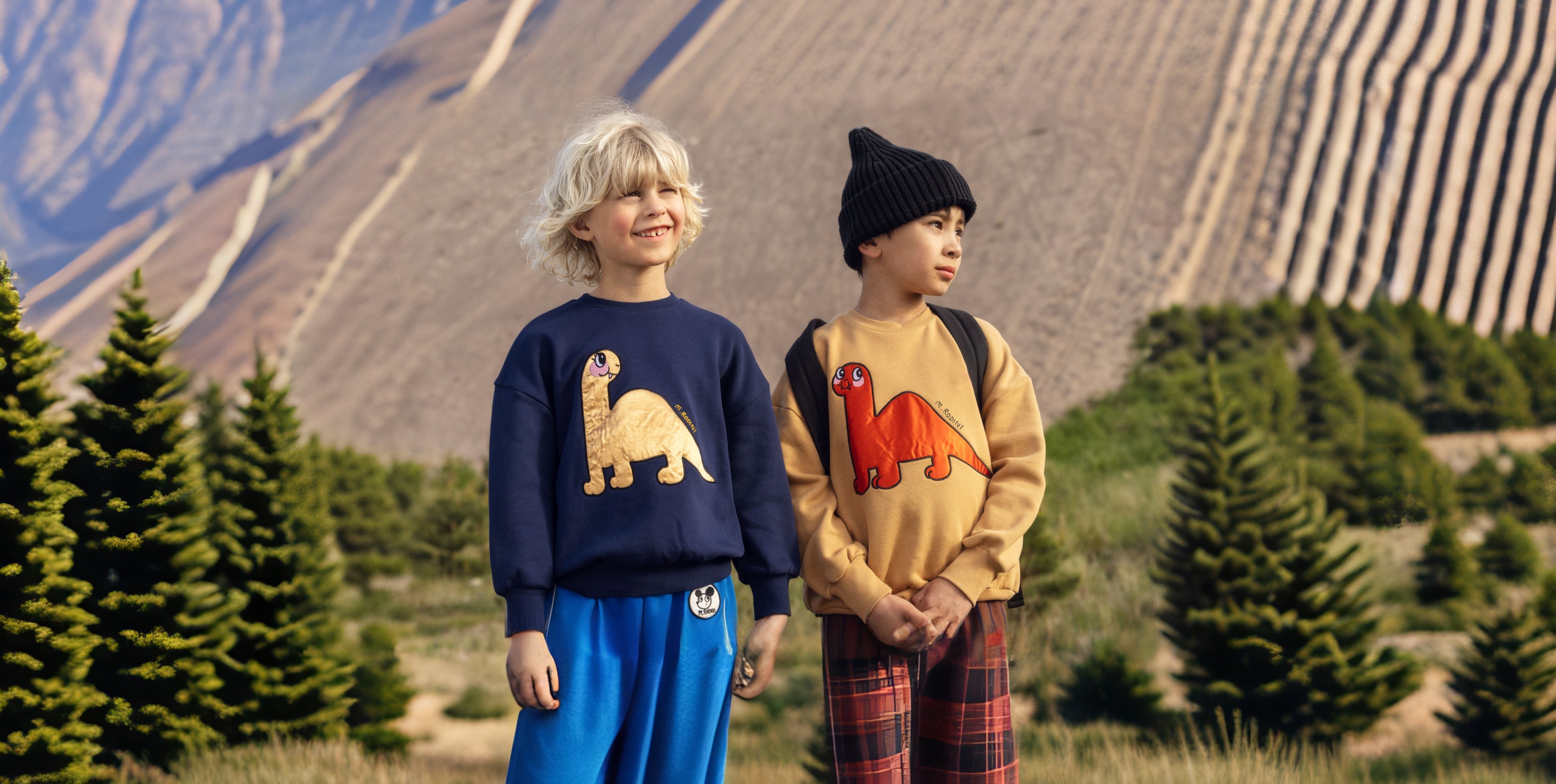 2 young boys wearing dino mini rodini sweatshirts