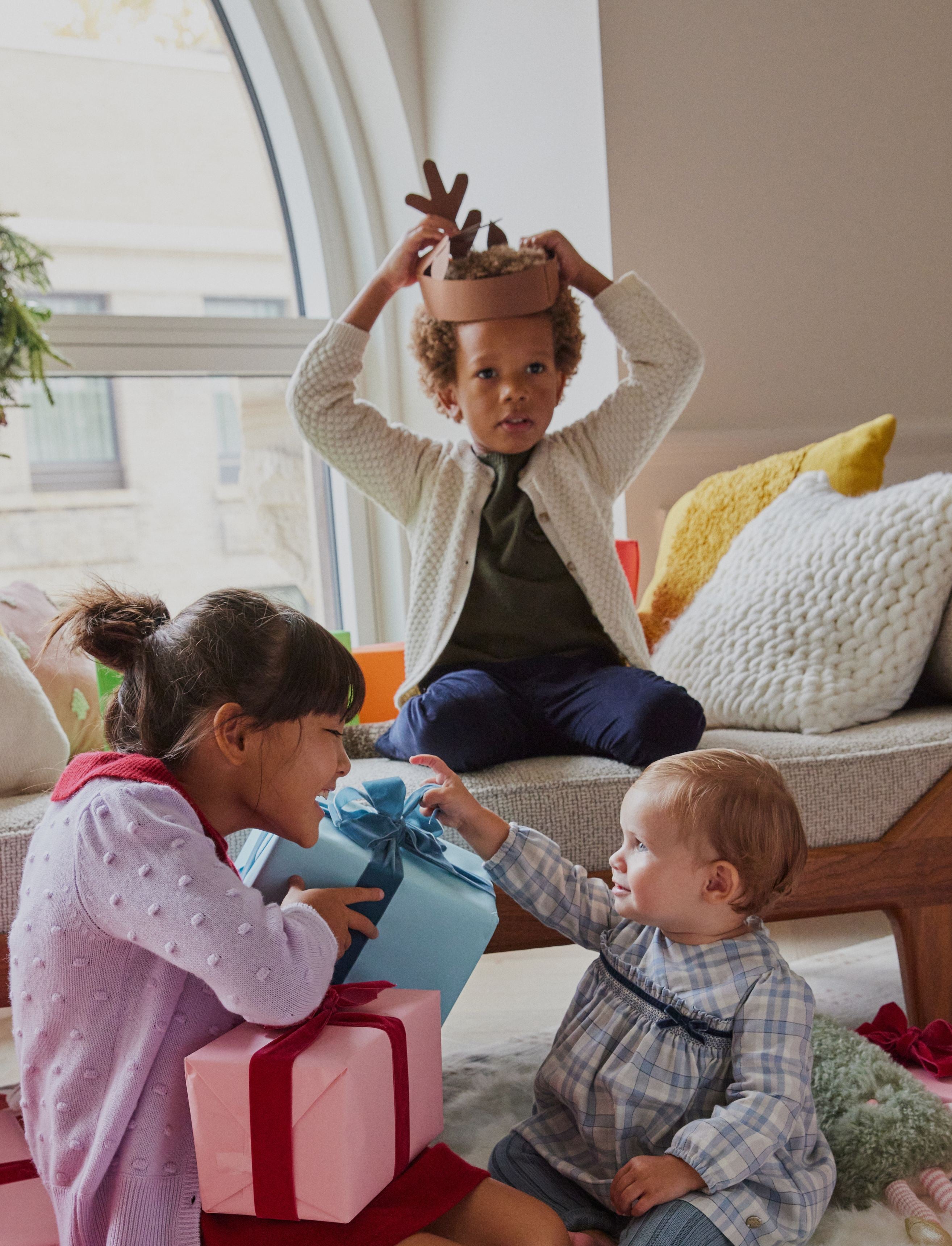 3 kids playing with colorful presents