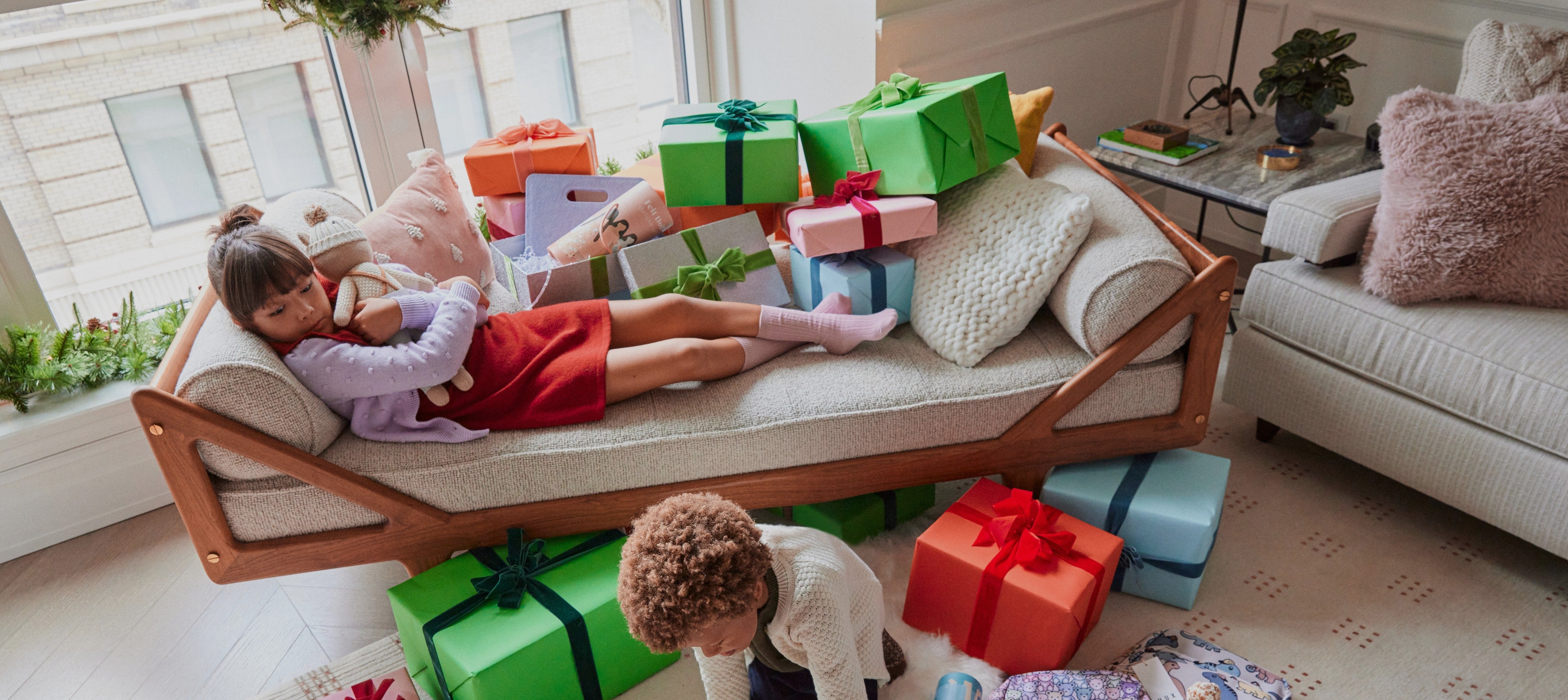 girl laying on pile of presents