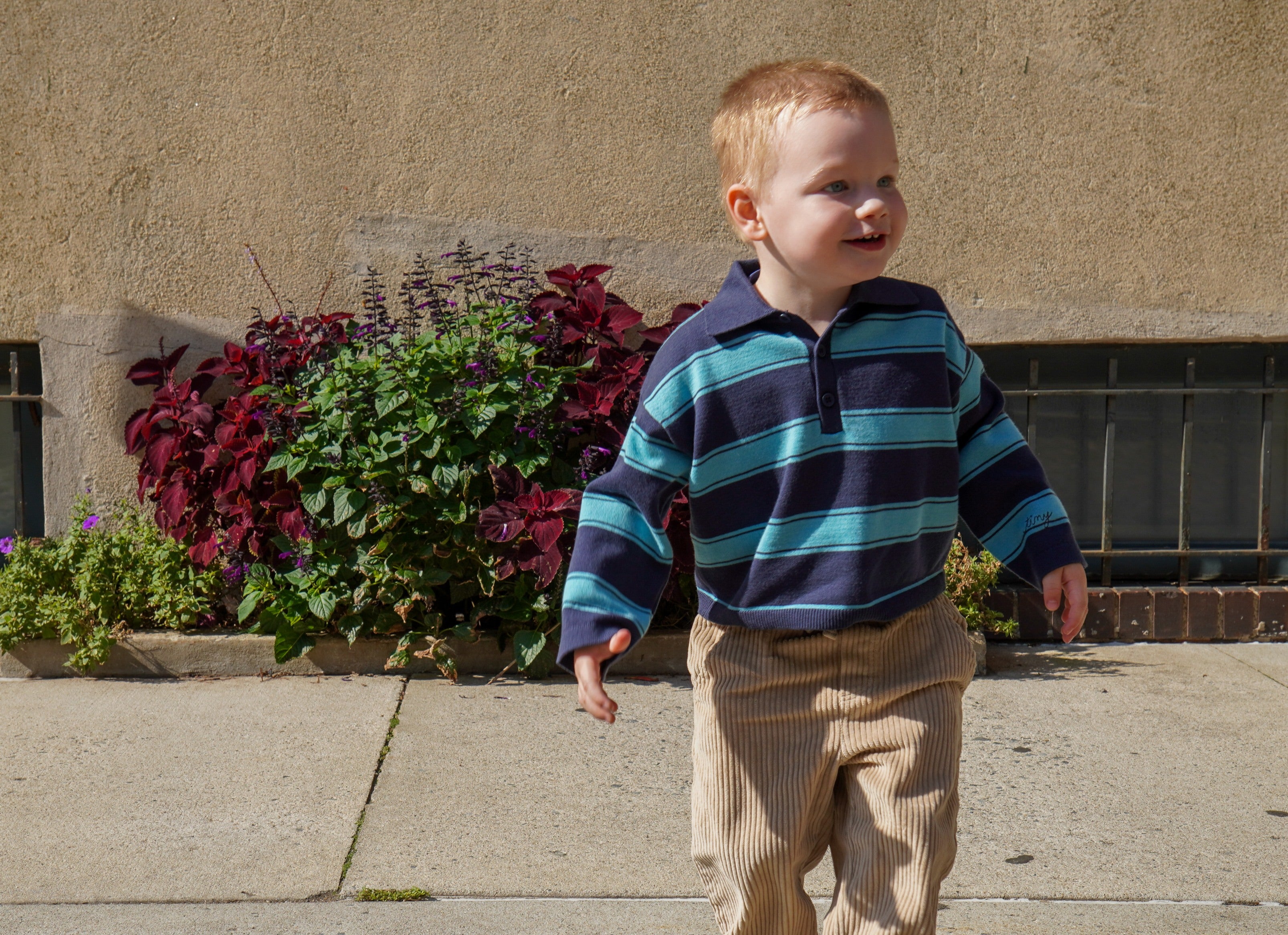 boy wearing blue striped polo and corduroy pants