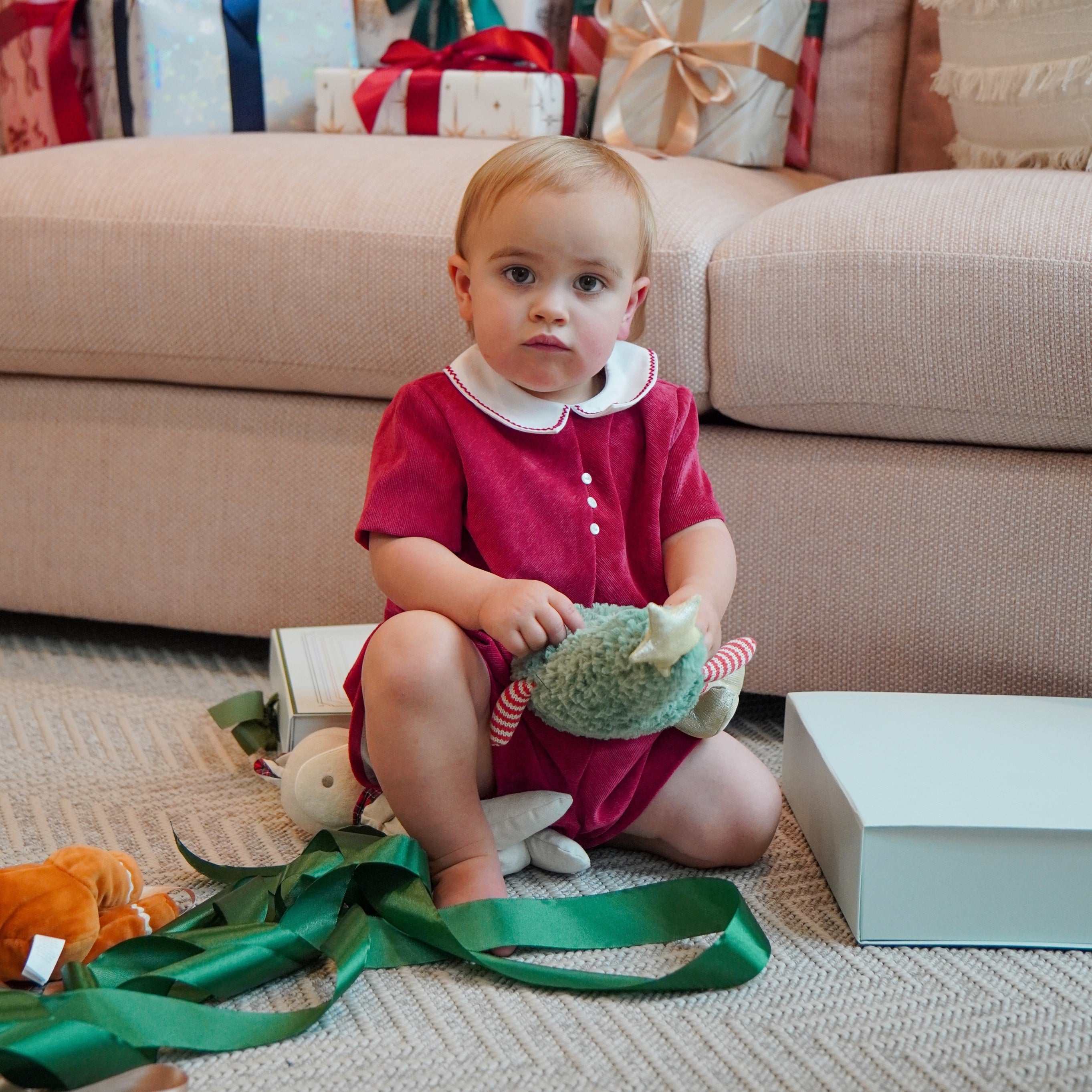baby boy playing with christmas-themed plush