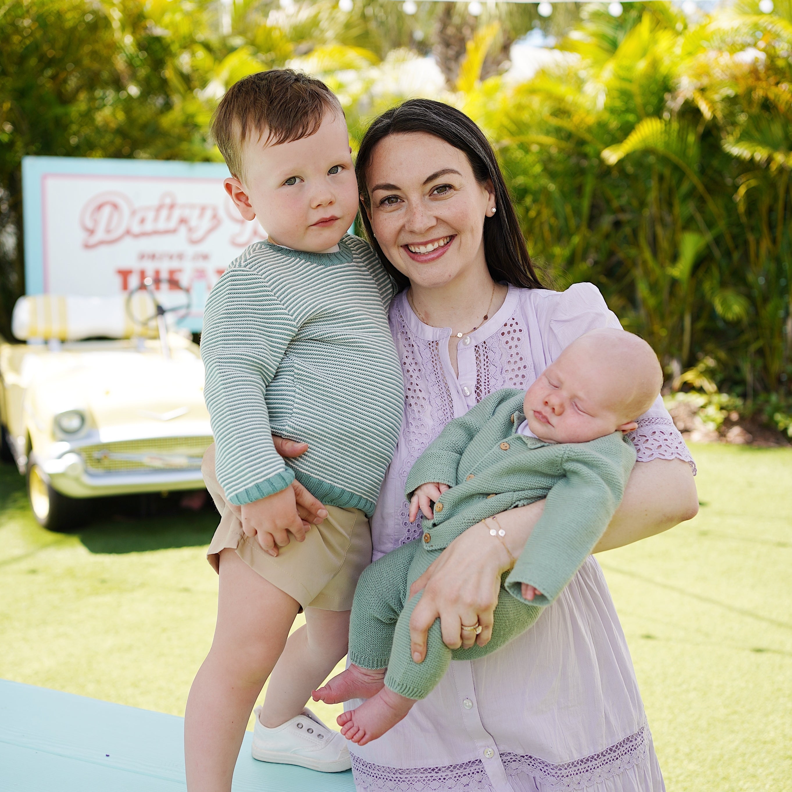woman holding her son and her baby