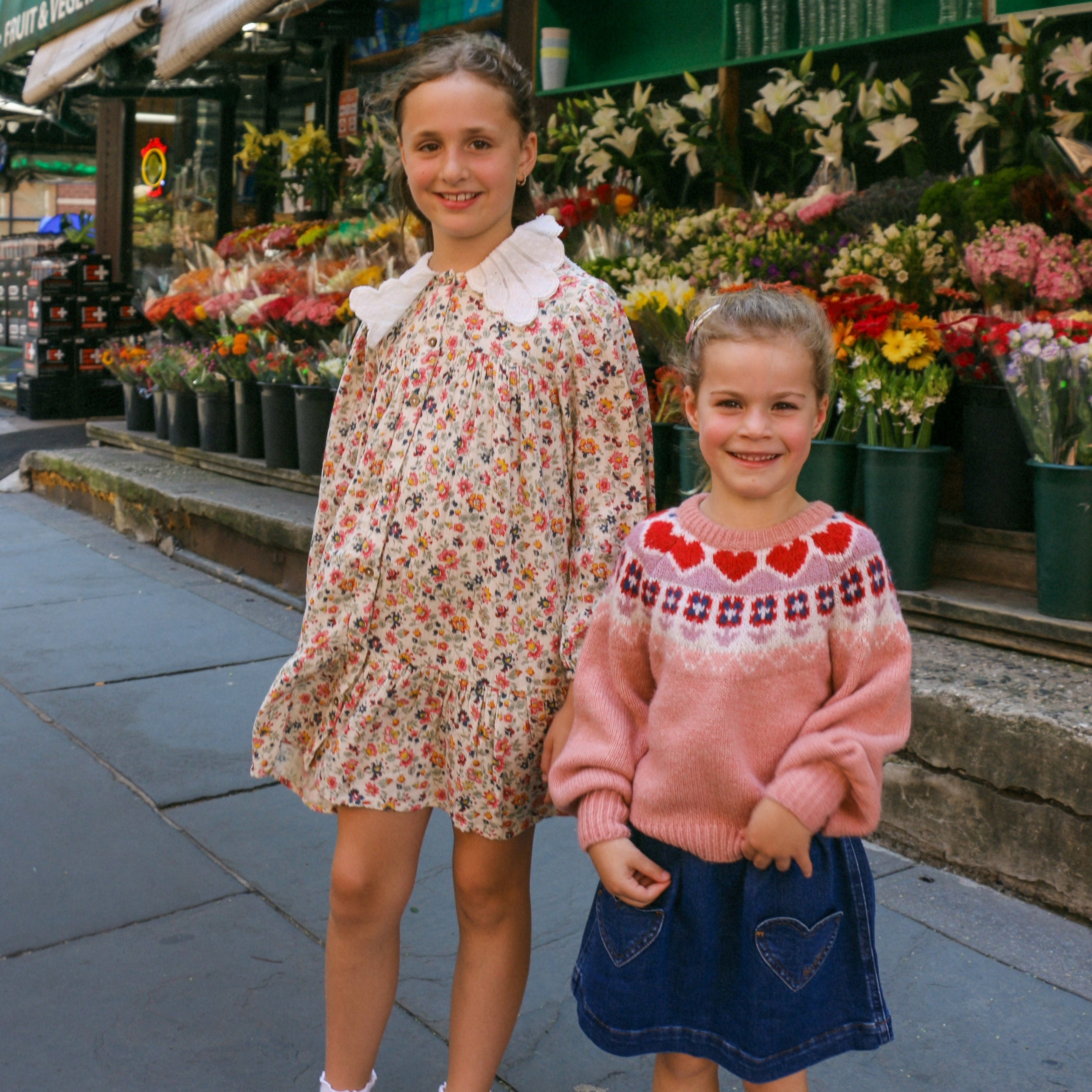 two young girls wearing danrie clothes in front of bodega in nyc