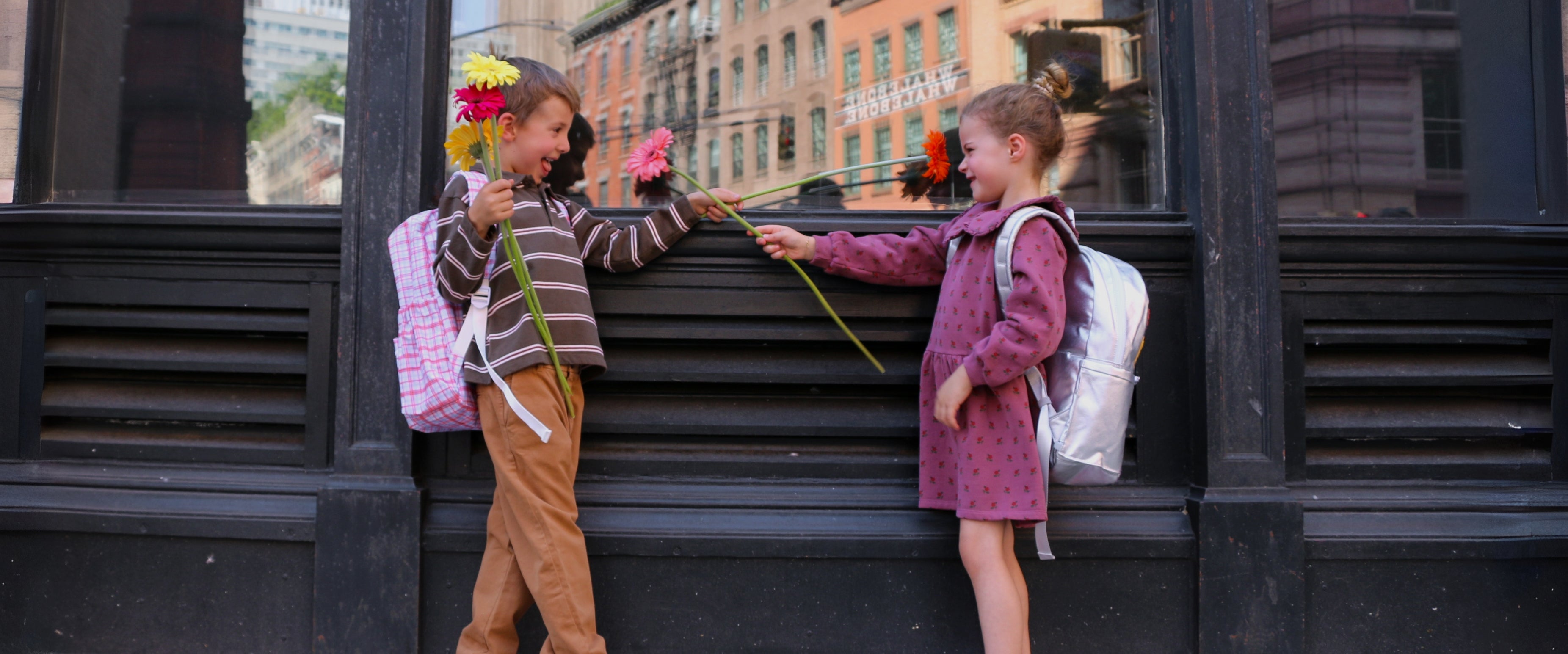 young girl and boy wearing danrie clothes and backpacks in a nyc street