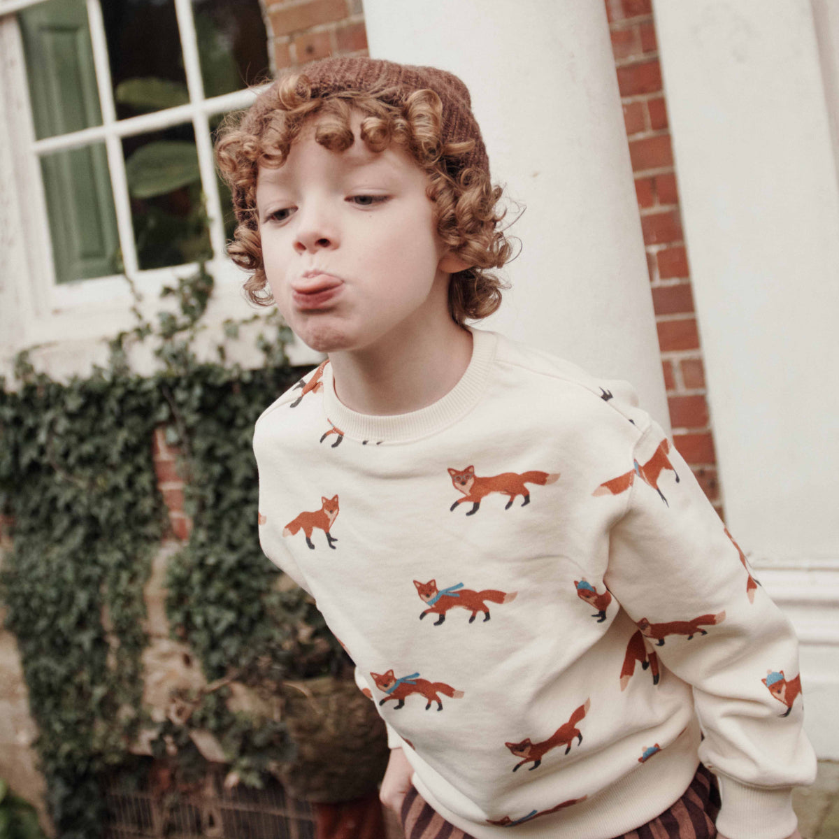 a young boy wearing a sweatshirt with foxes on it