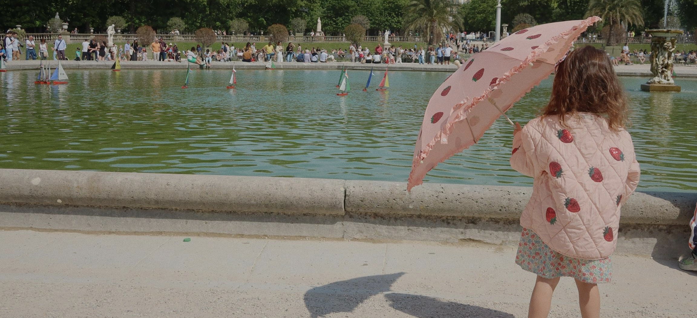 girl holding strawberry print umbrella