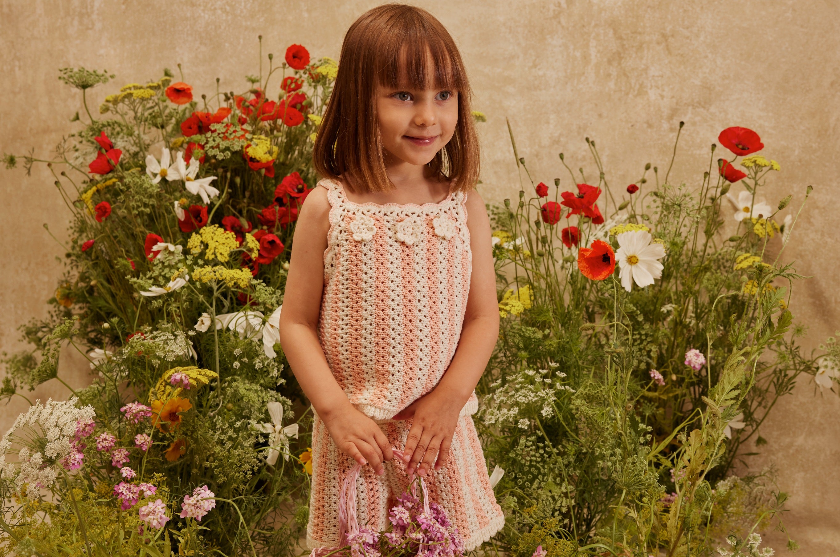 girl wearing louise misha set in front of flowers