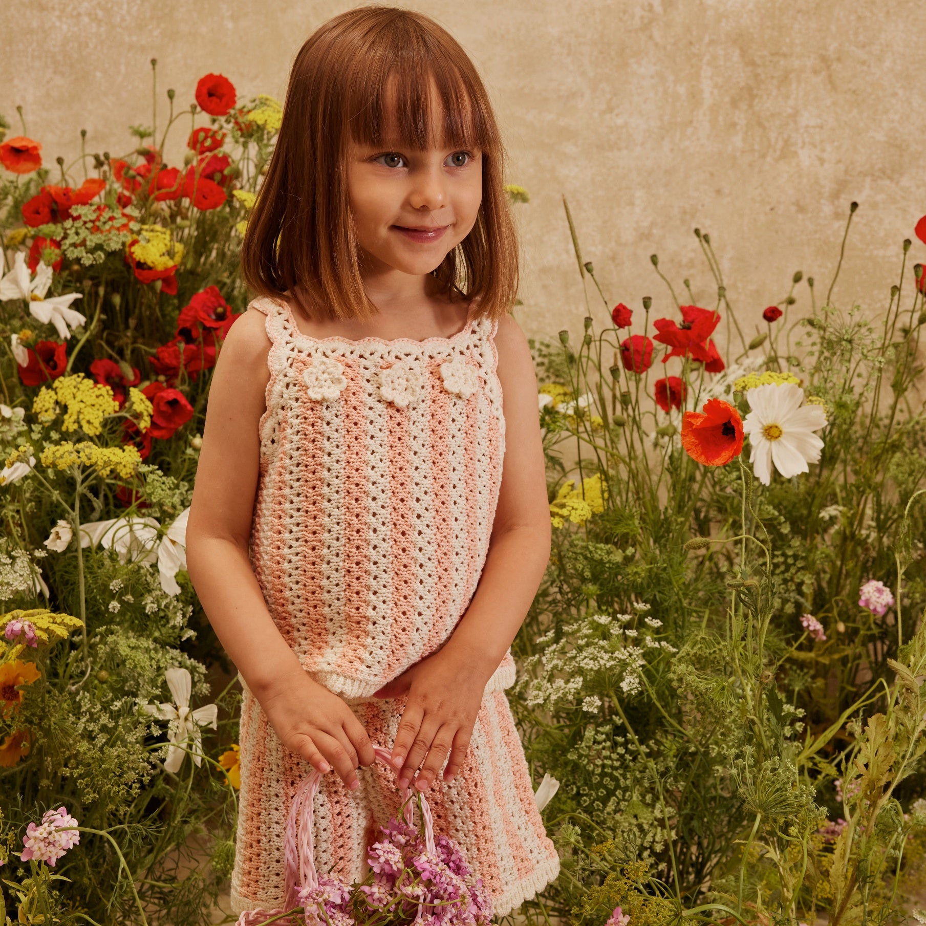 girl wearing louise misha set in front of flowers