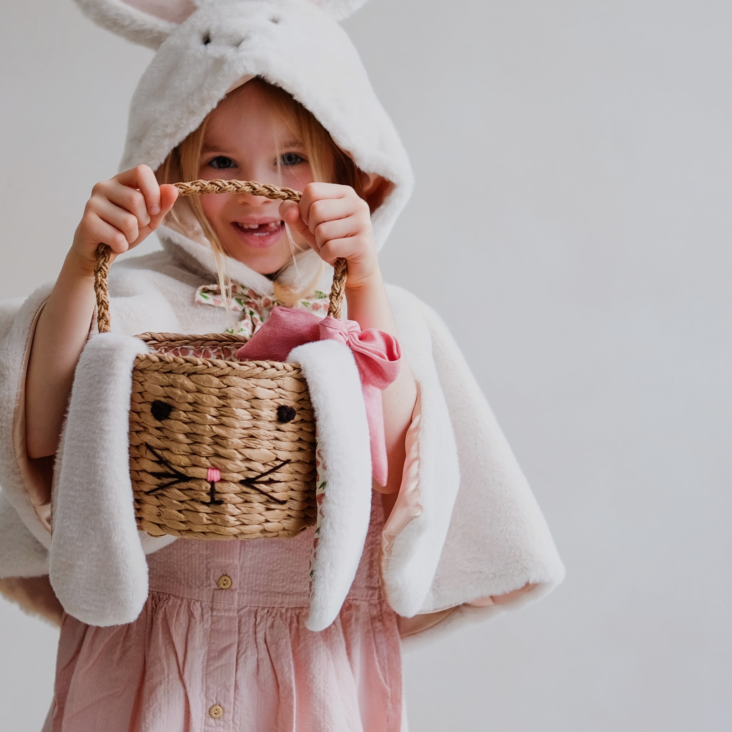 little girl holding rattan bunny easter basket