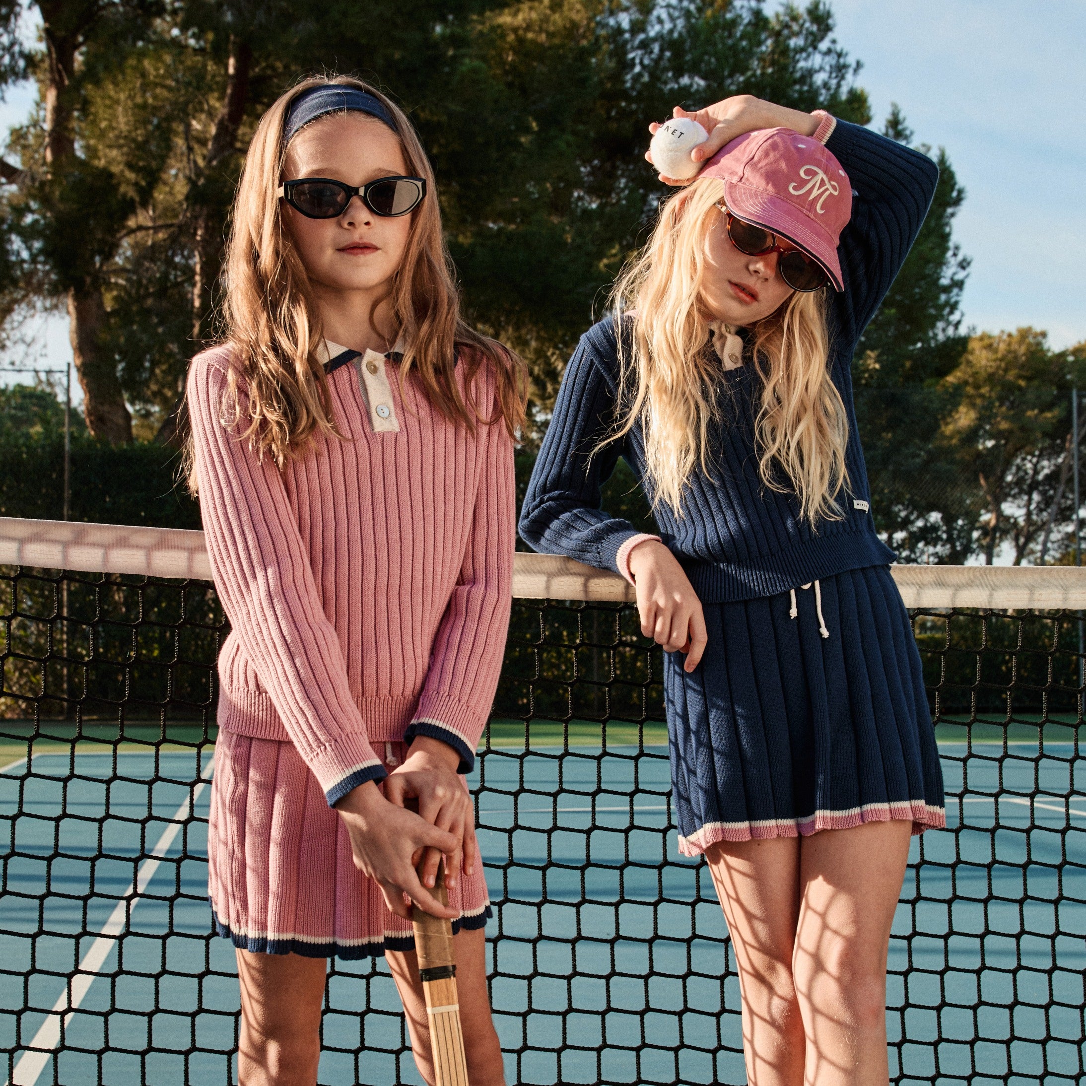 2 girls wearing knit skirt set on tennis court