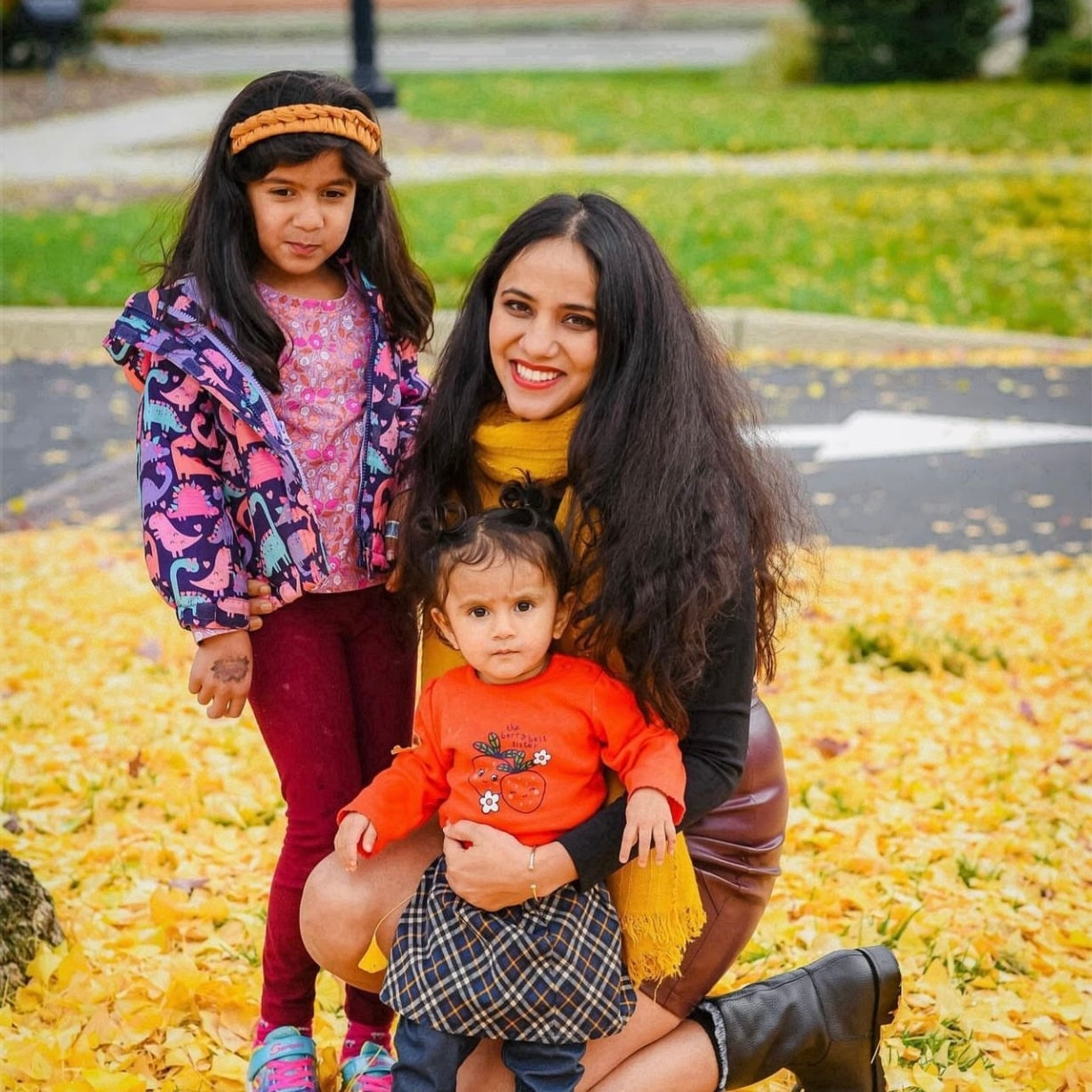 mom with two daughters standing in leaves