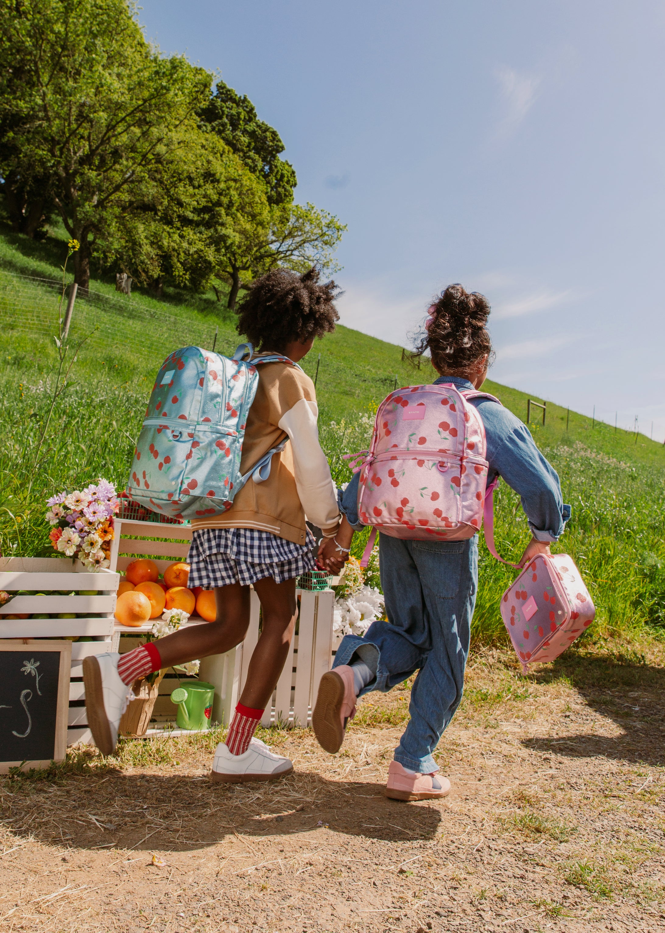 two girls running with backpacks on