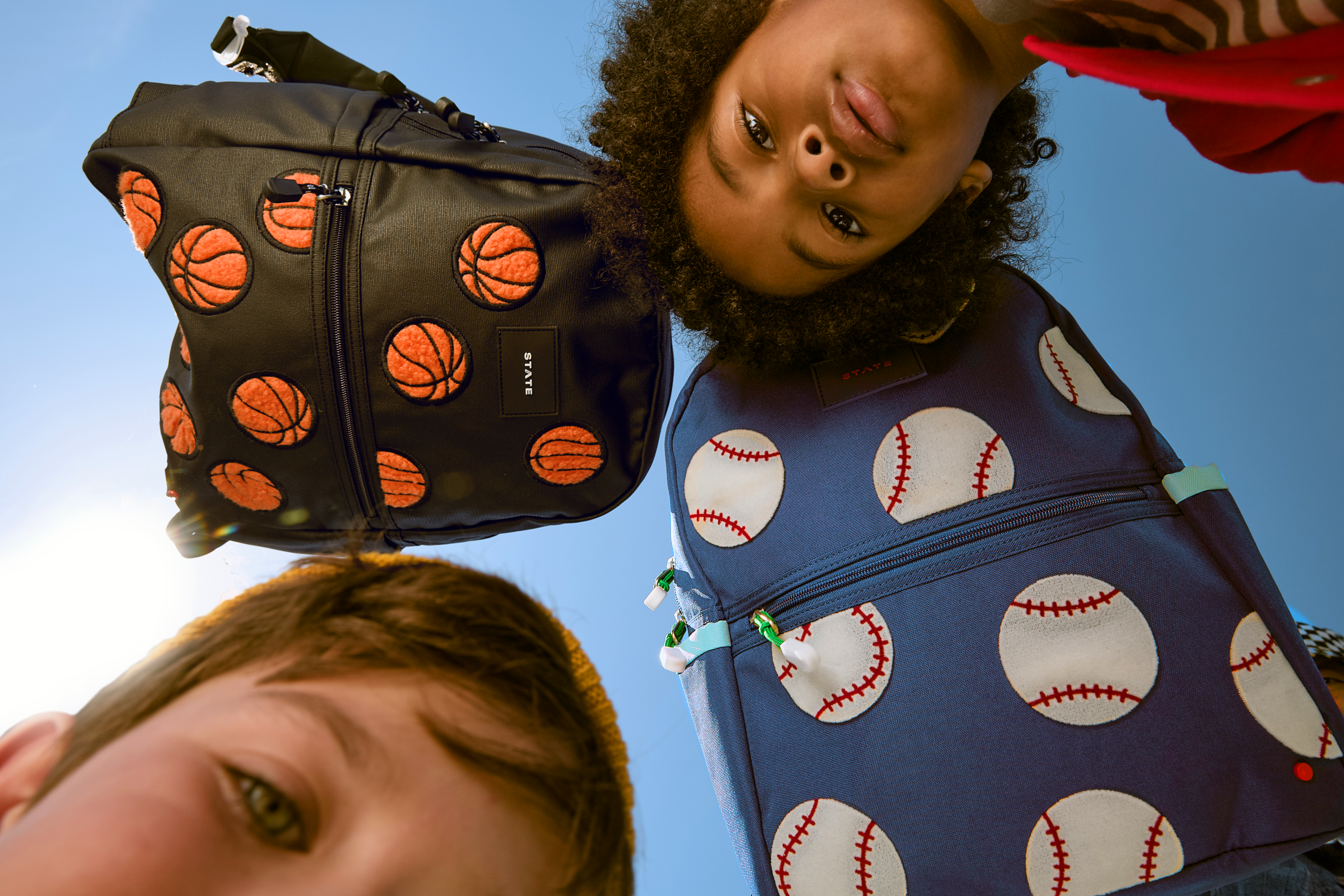 two boys with a baseball and basketball backpack