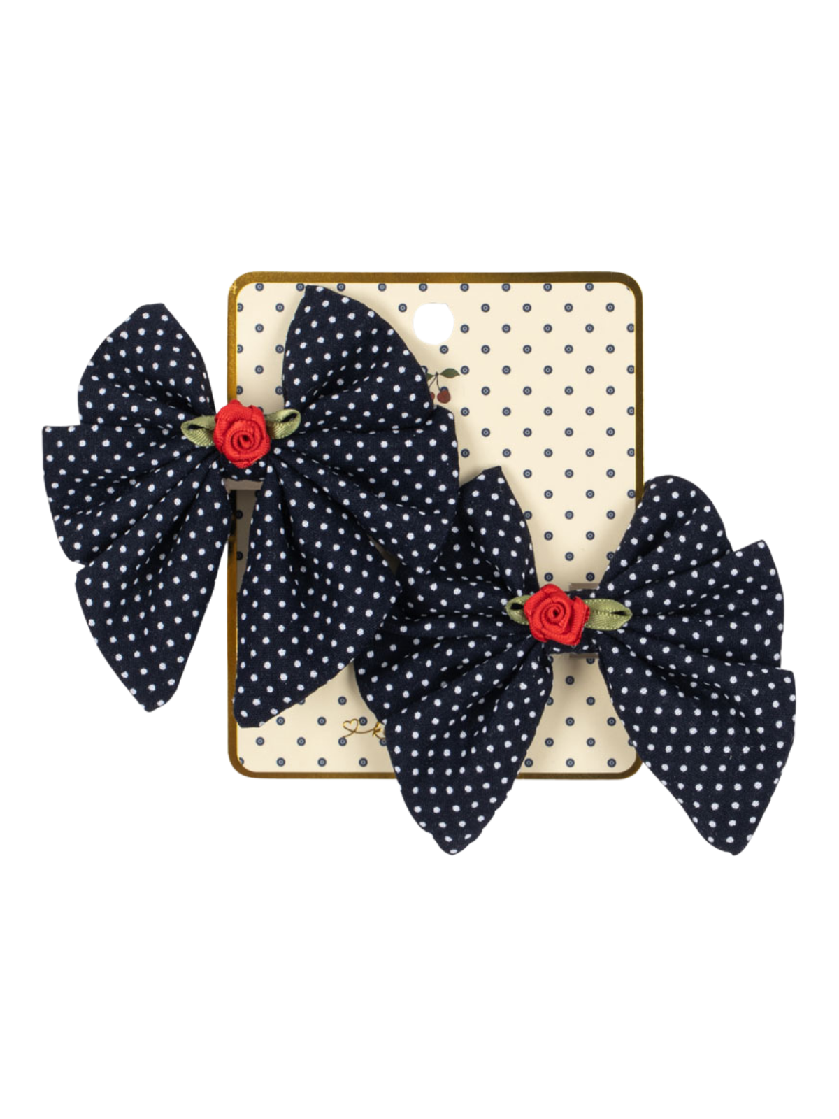 Two navy blue polka dot hair bows with red floral accents displayed on a cream polka dot backing card.
