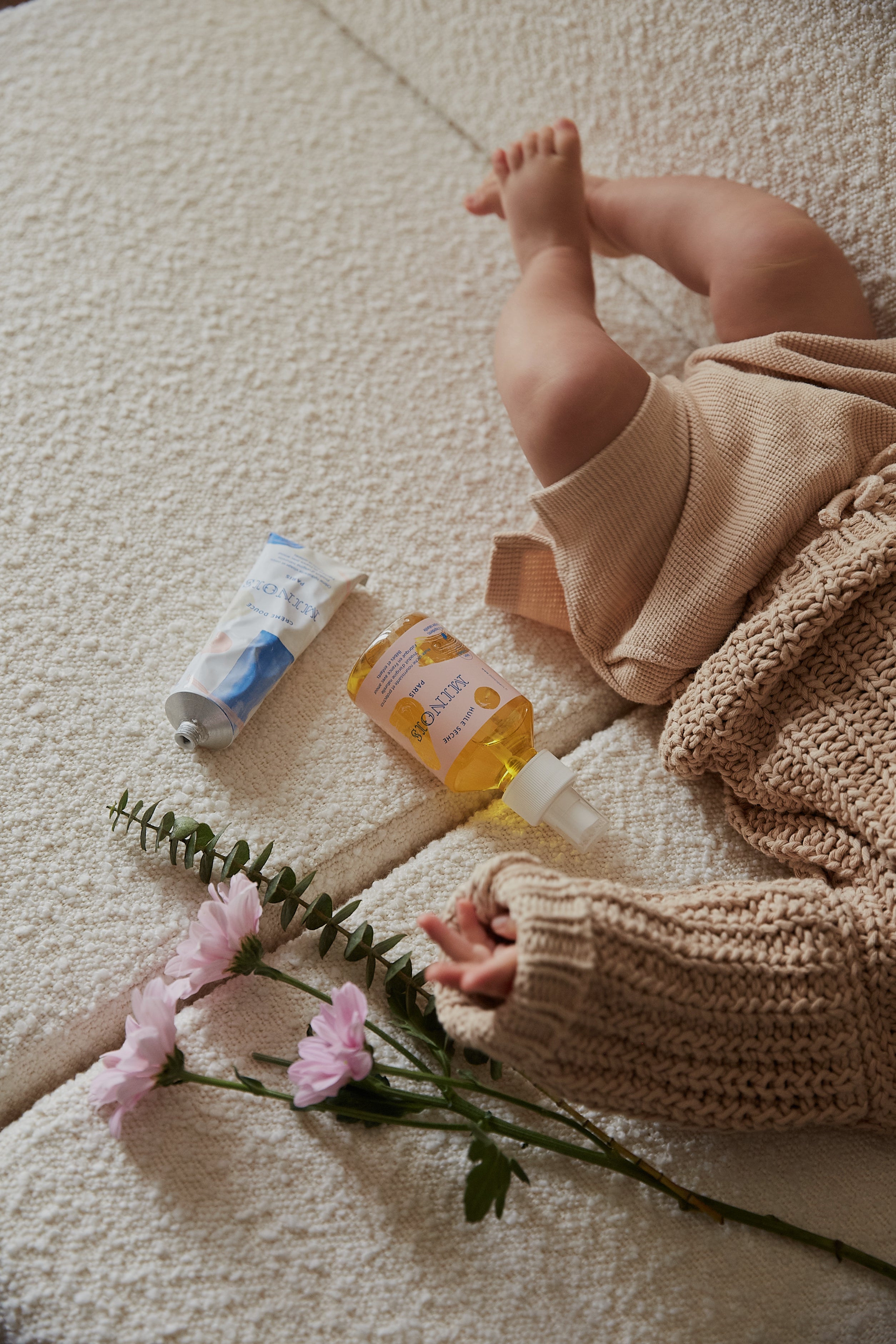 baby laying next to minois bath products