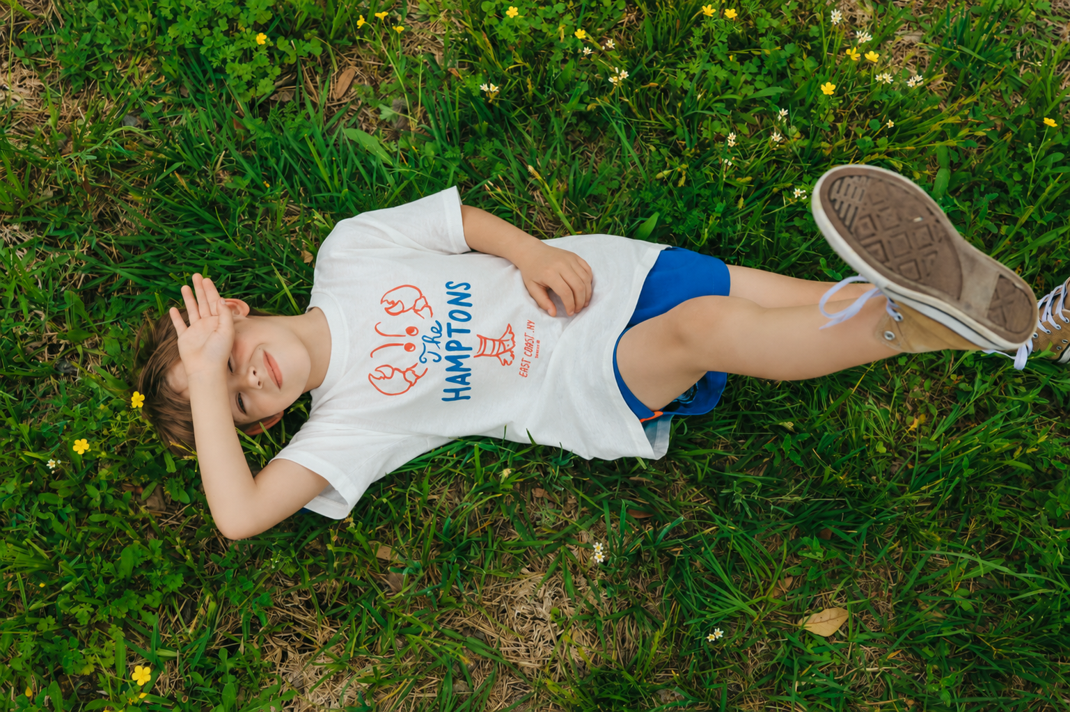 boy in camp clothes in grass