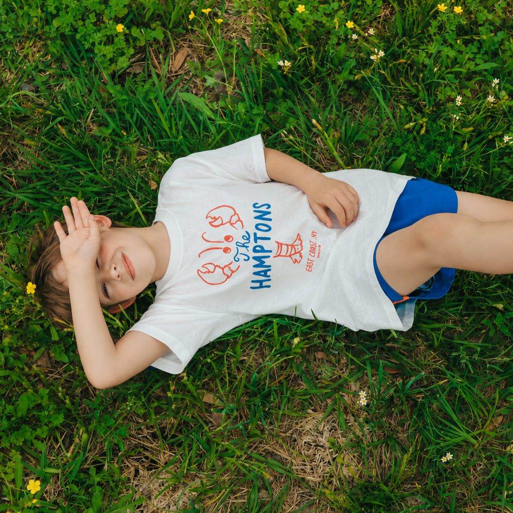 boy in camp clothes in grass